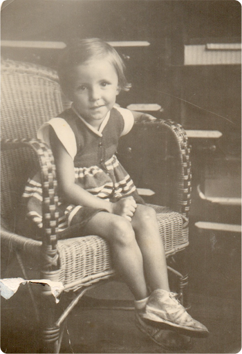 A young girl seated in a wicker chair